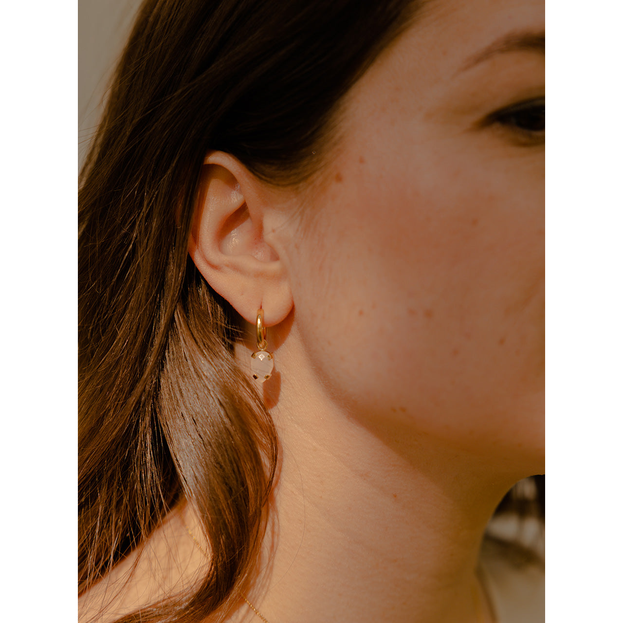 These subtle earrings are infused with elegance and a touch of playfulness. They showcase small hoops, each adorned with a distinct pendant.