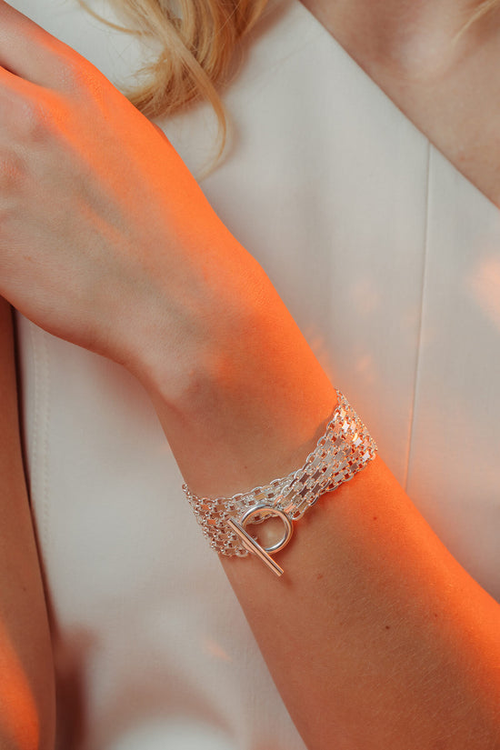 Drip T-lock bracelet featuring a layered chain design with a T-bar toggle clasp worn on the wrist.