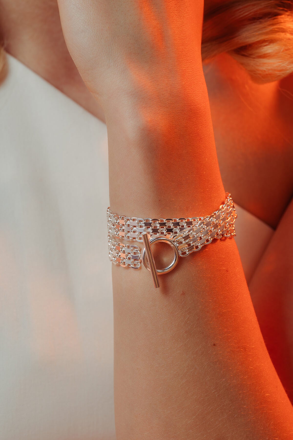 Drip T-lock bracelet showing the layered chain bracelet with a front-facing T-bar toggle clasp on the wrist.