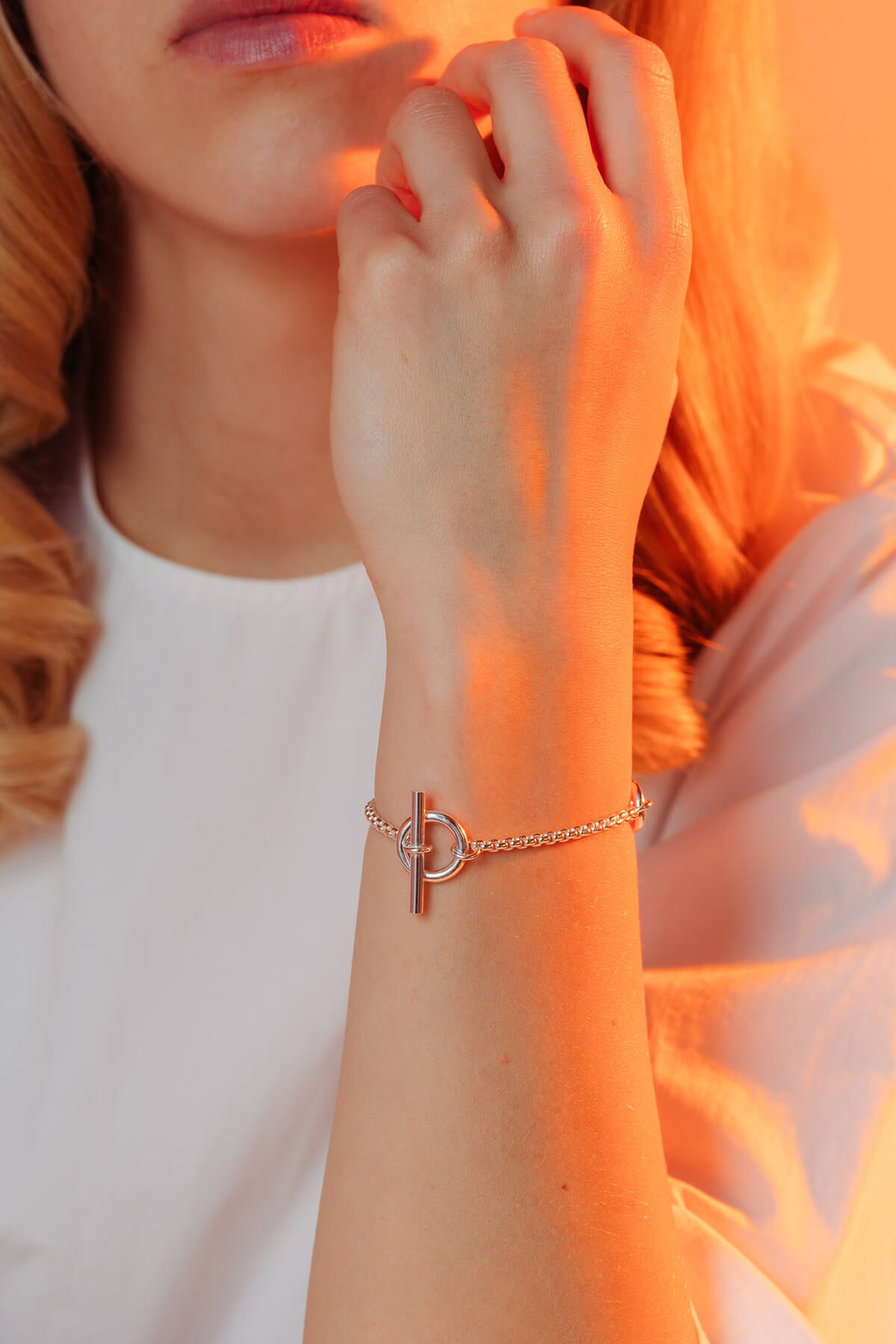 Splash bracelet in silver featuring oval shapes on a fine chain with a T-lock clasp worn on the wrist.