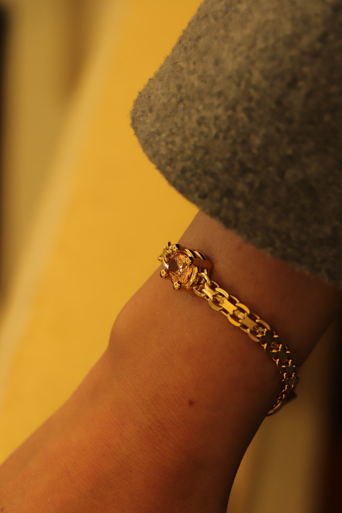 Drip T-lock bracelet with an oval-cut orange cubic zirkonia detail worn on the wrist in a close-up.