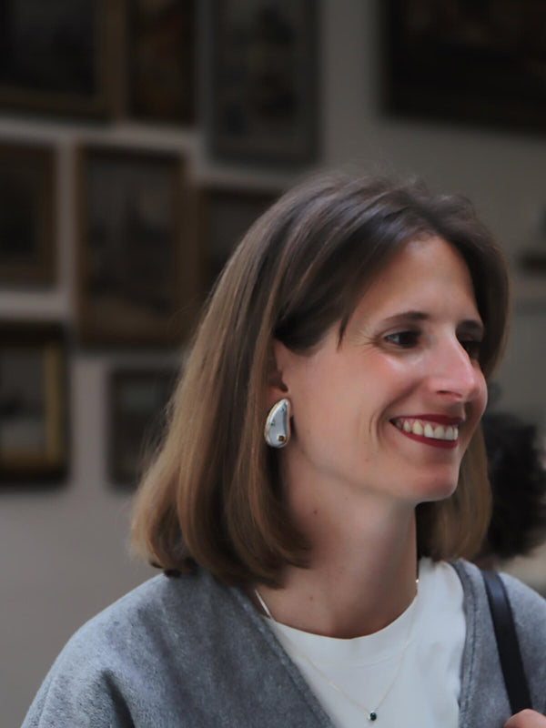 Hermien wearing Spill earrings and Bubble necklace with cubic zirconia in a smiling portrait.