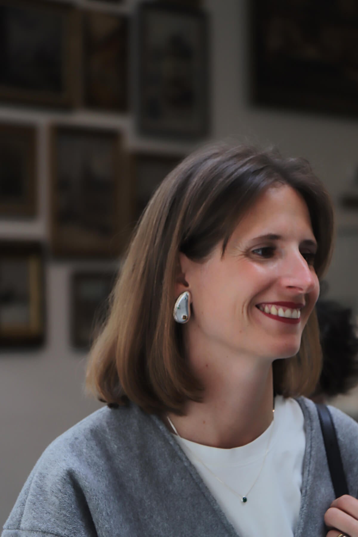 Hermien wearing Spill earrings and Bubble necklace with cubic zirconia in a smiling portrait.