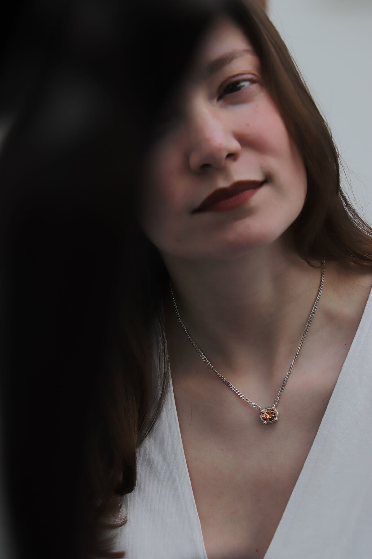 Magaly wearing Drip necklace with oval-cut orange cubic zirconia at La Piscine Musée Roubaix.