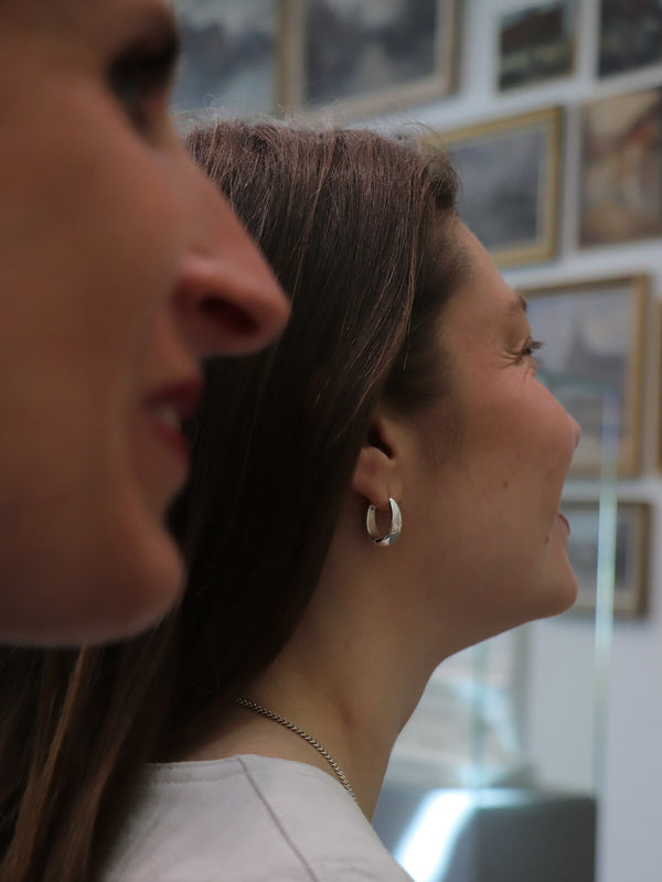 Magaly wearing Splash hoops at La Piscine Musée Roubaix with gallery paintings in the background.