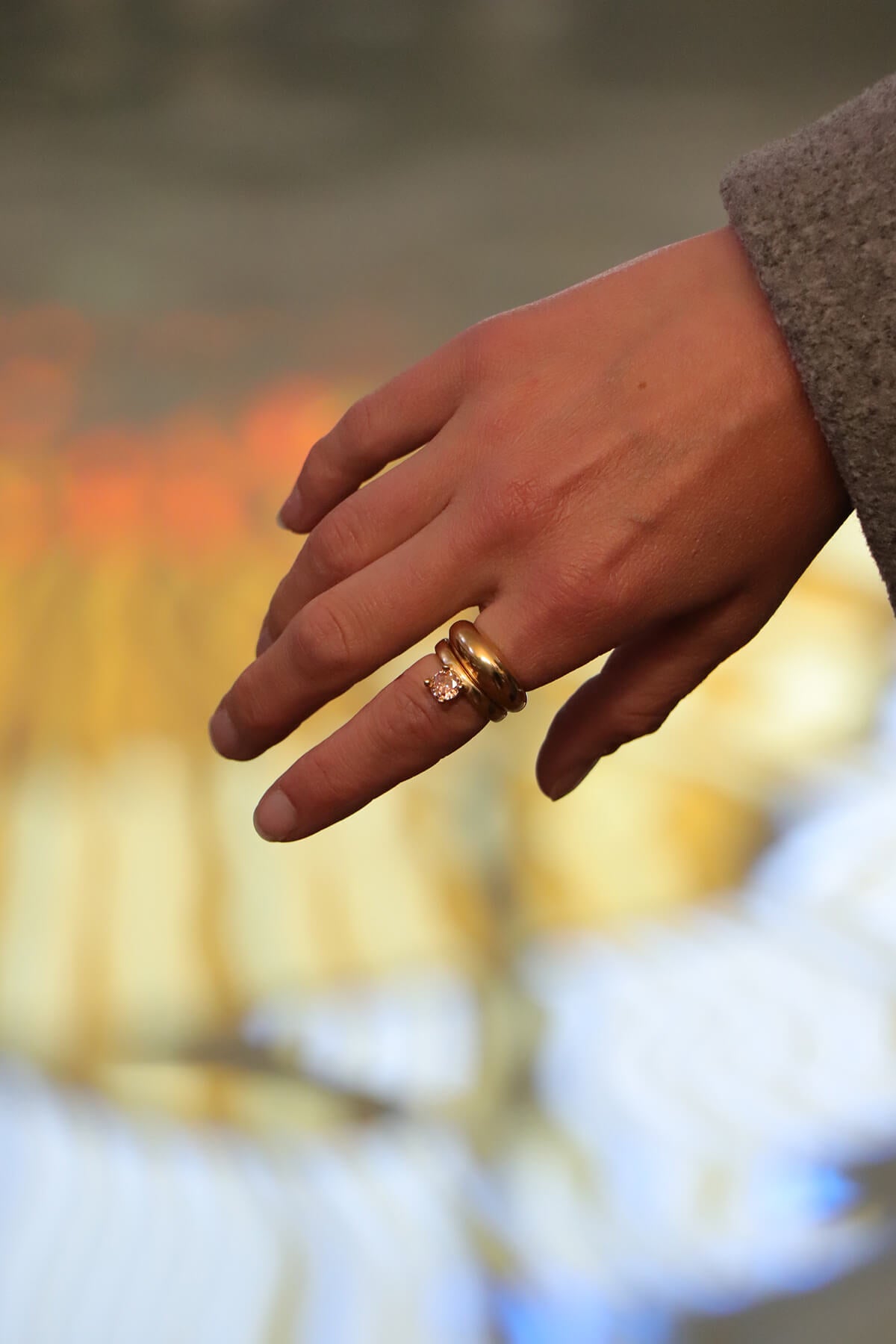 Drip ring with round cubic zirconia worn on the finger in a close-up hand portrait at La Piscine Musée Roubaix.