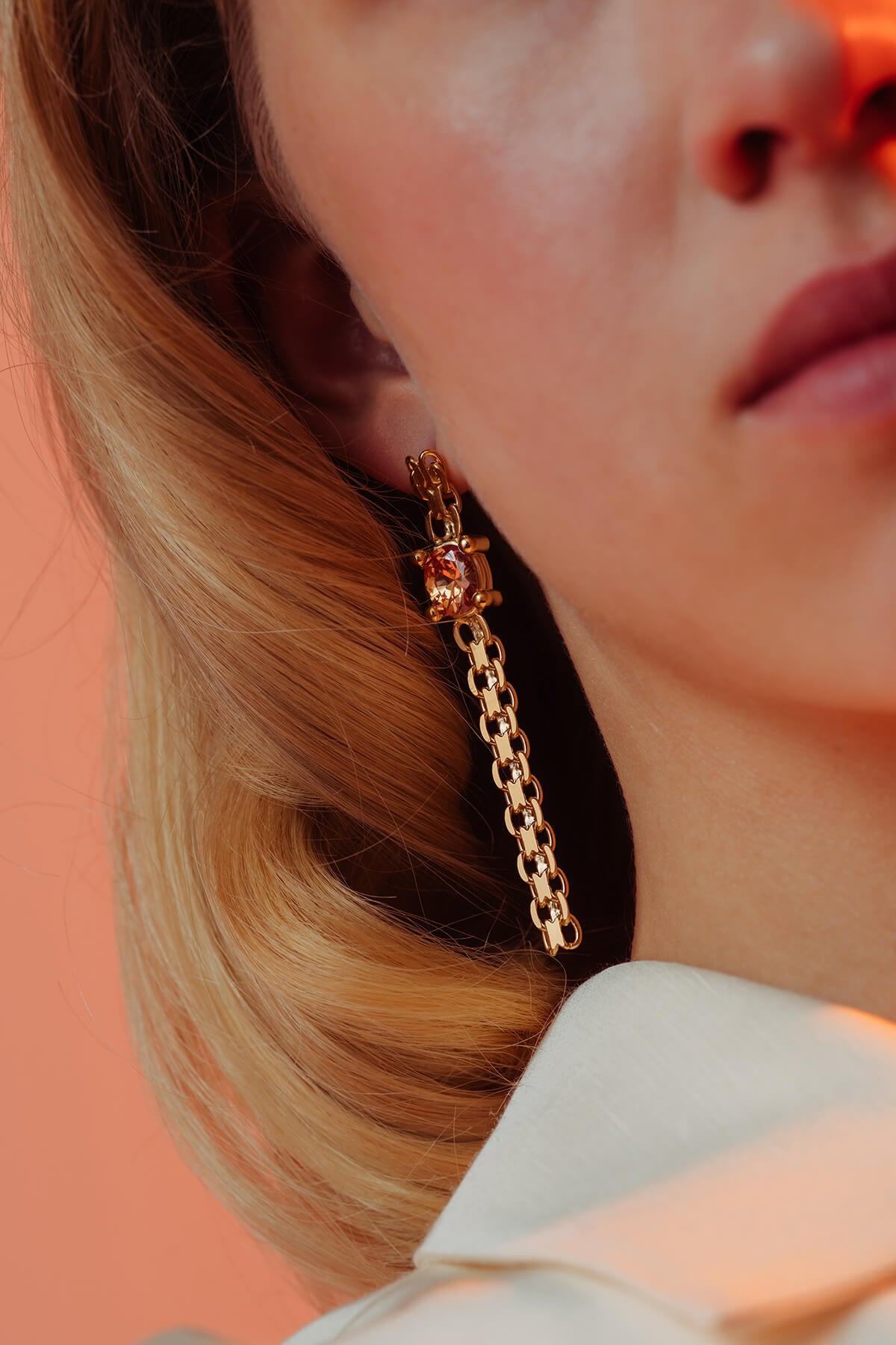 Drip earrings with an oval orange cubic zirconia in an oversized four-prong setting and flexible chain drops.