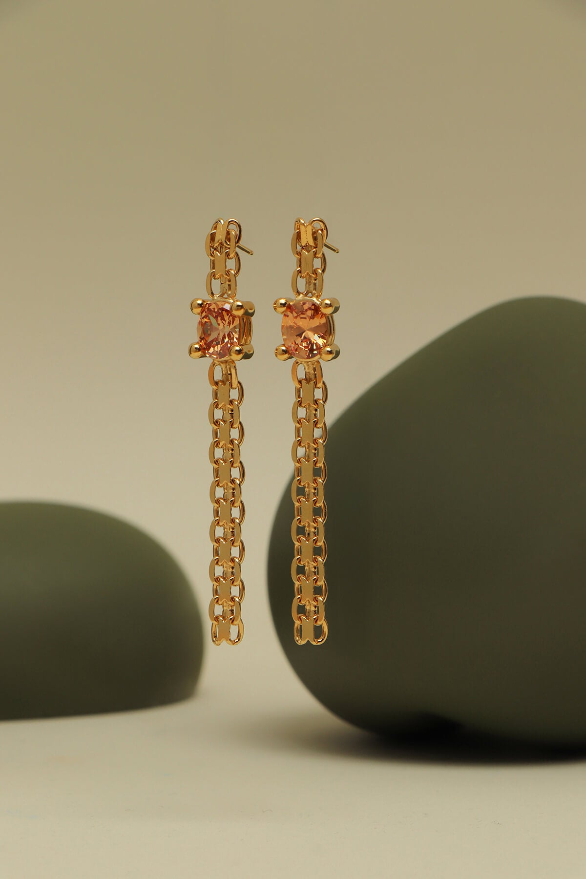 Drip earrings with cubic zirconia featuring oversized four-prong settings and chain drops between sculptural green forms.
