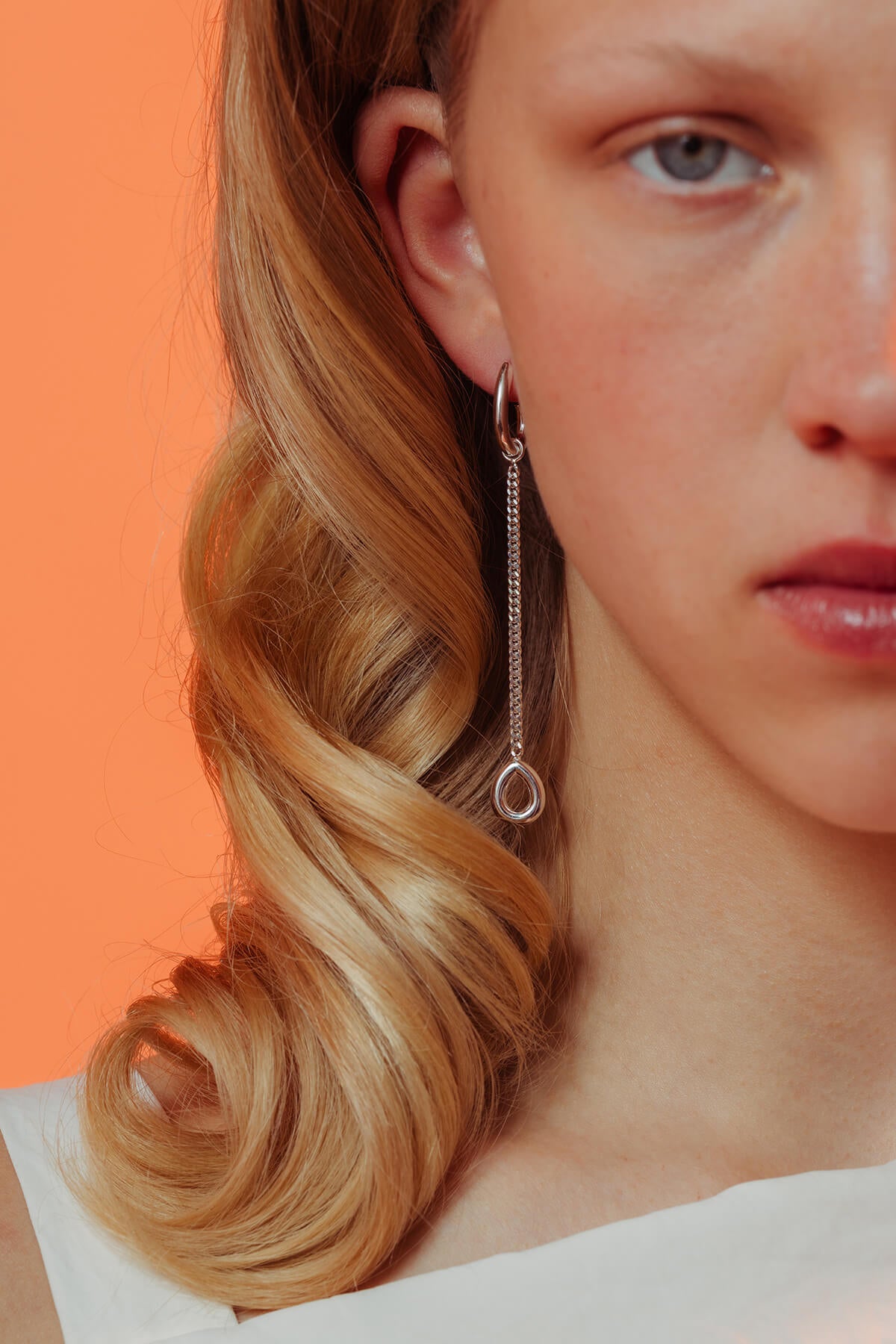 Splash earrings in silver featuring a detachable fine chain and drop pendant hanging from a droplet-shaped hoop.