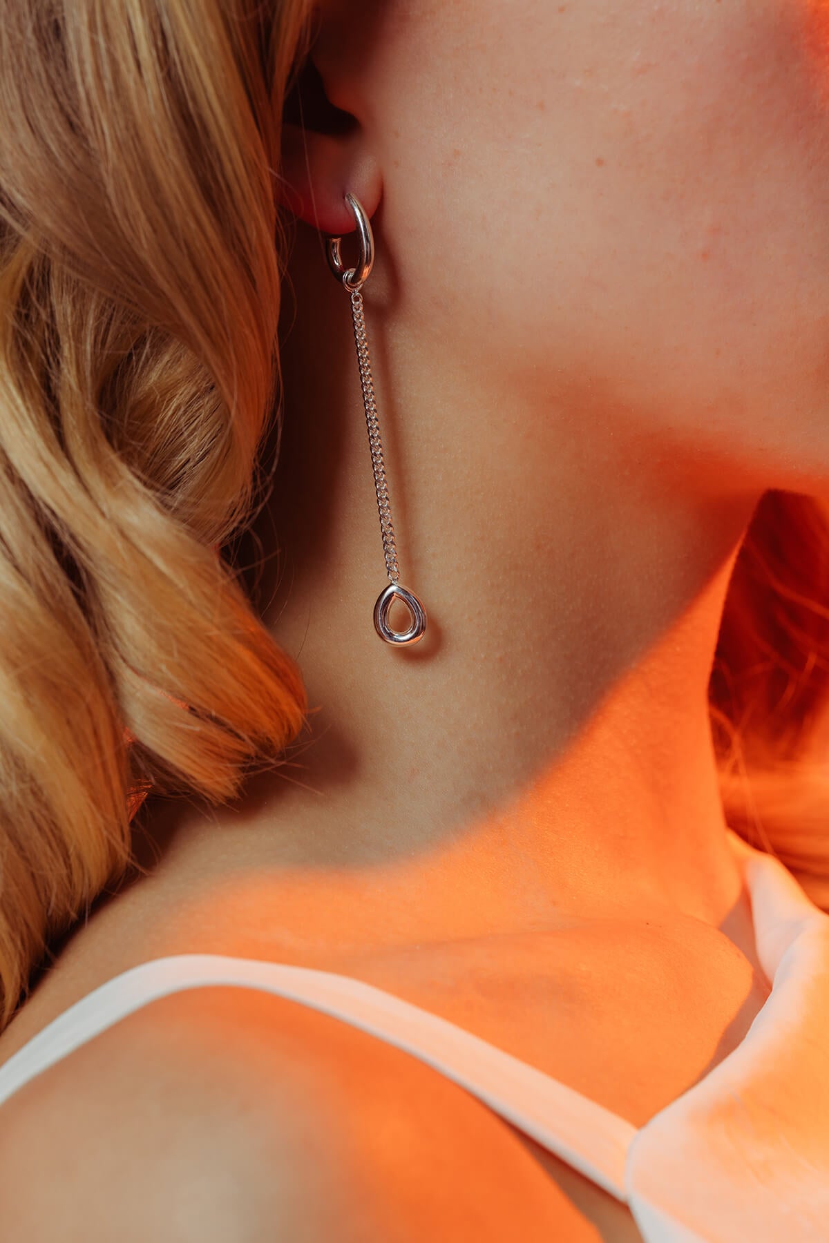 Splash earrings in silver featuring a long fine chain and removable drop pendant styled in the ear.