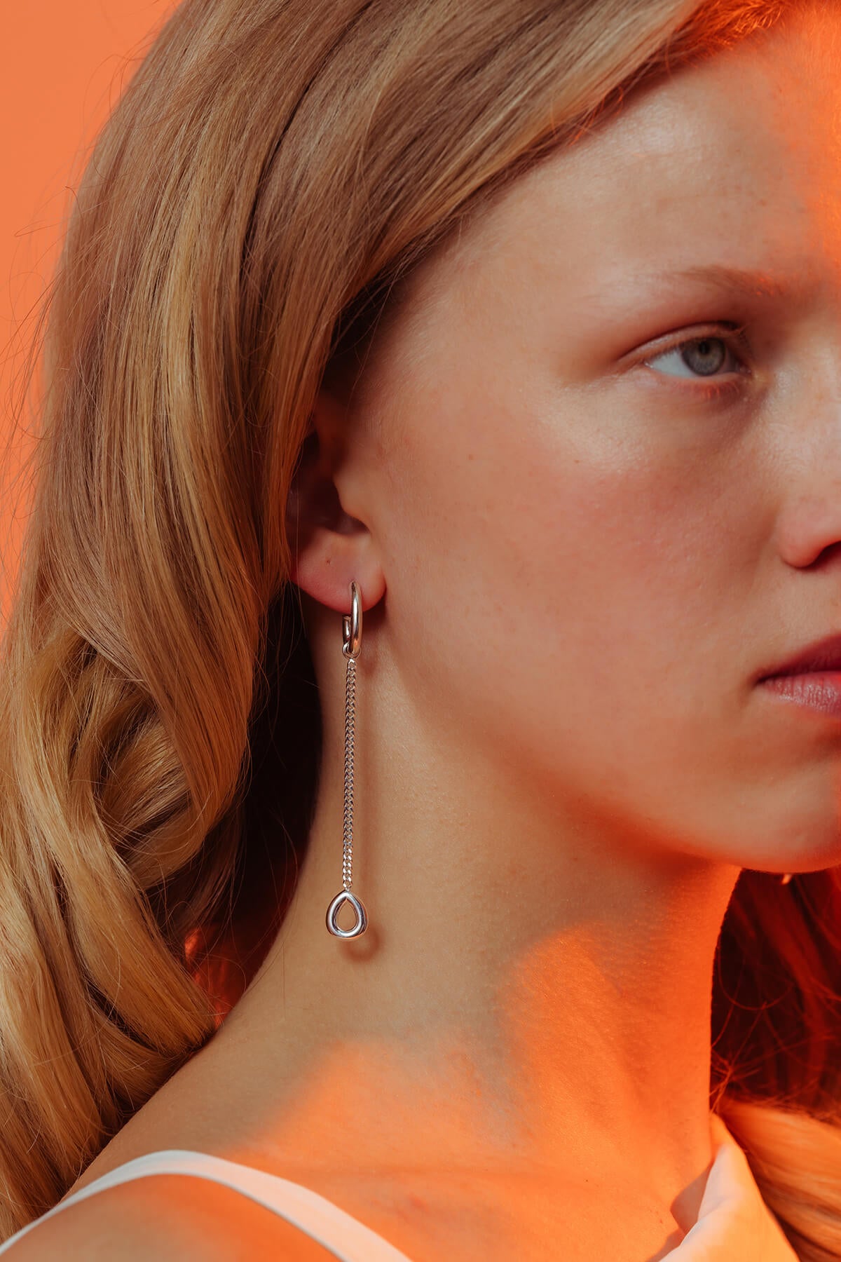 Splash earrings in silver with a droplet-shaped hoop and removable drop pendant shown hanging from the ear.