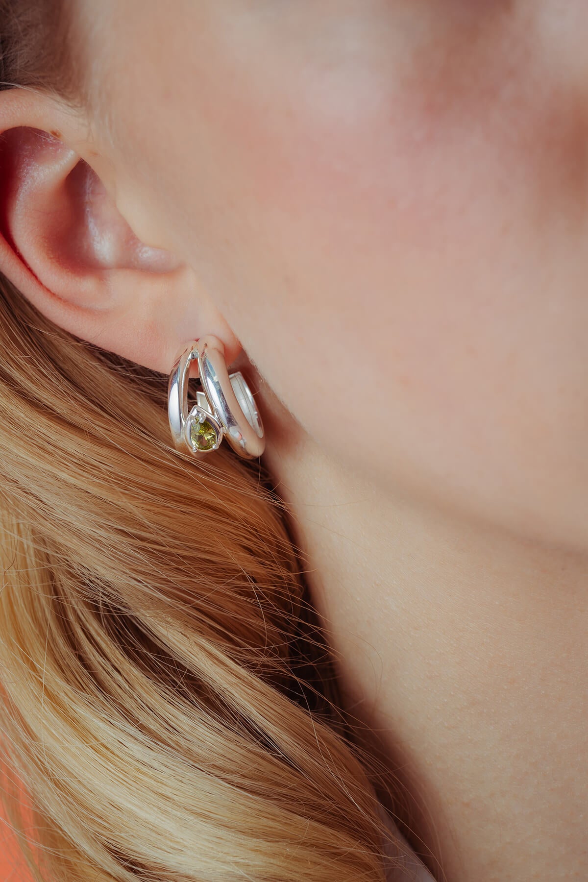 Drop hoops with cubic zirconia in silver with contrasting hoop shapes framing a green pear-shaped cubic zirconia.