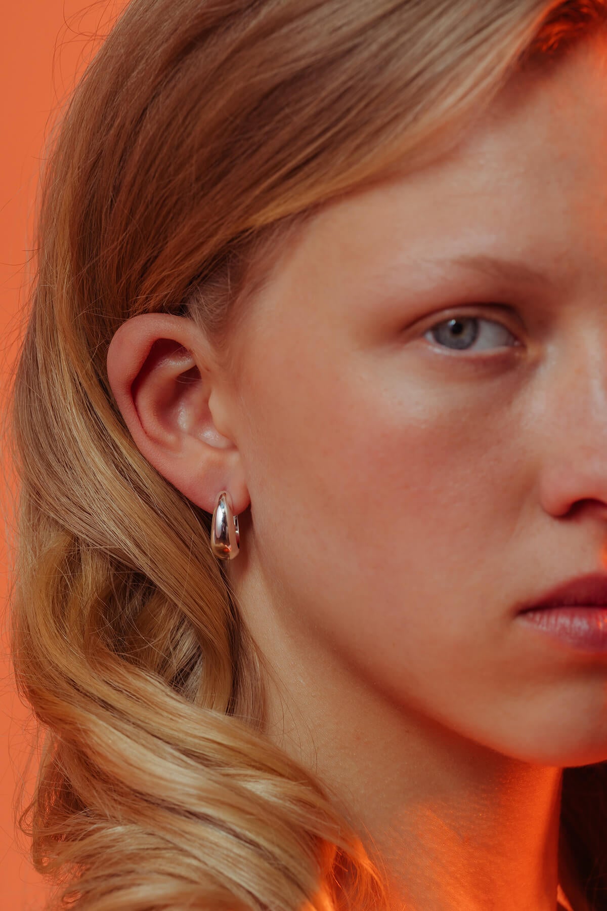Splash hoops in silver with rounded droplet-inspired hoops shown worn in the ear.