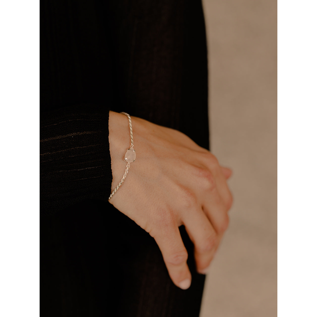 This charming bracelet showcases a lovely rose quartz in a graceful drop shape.