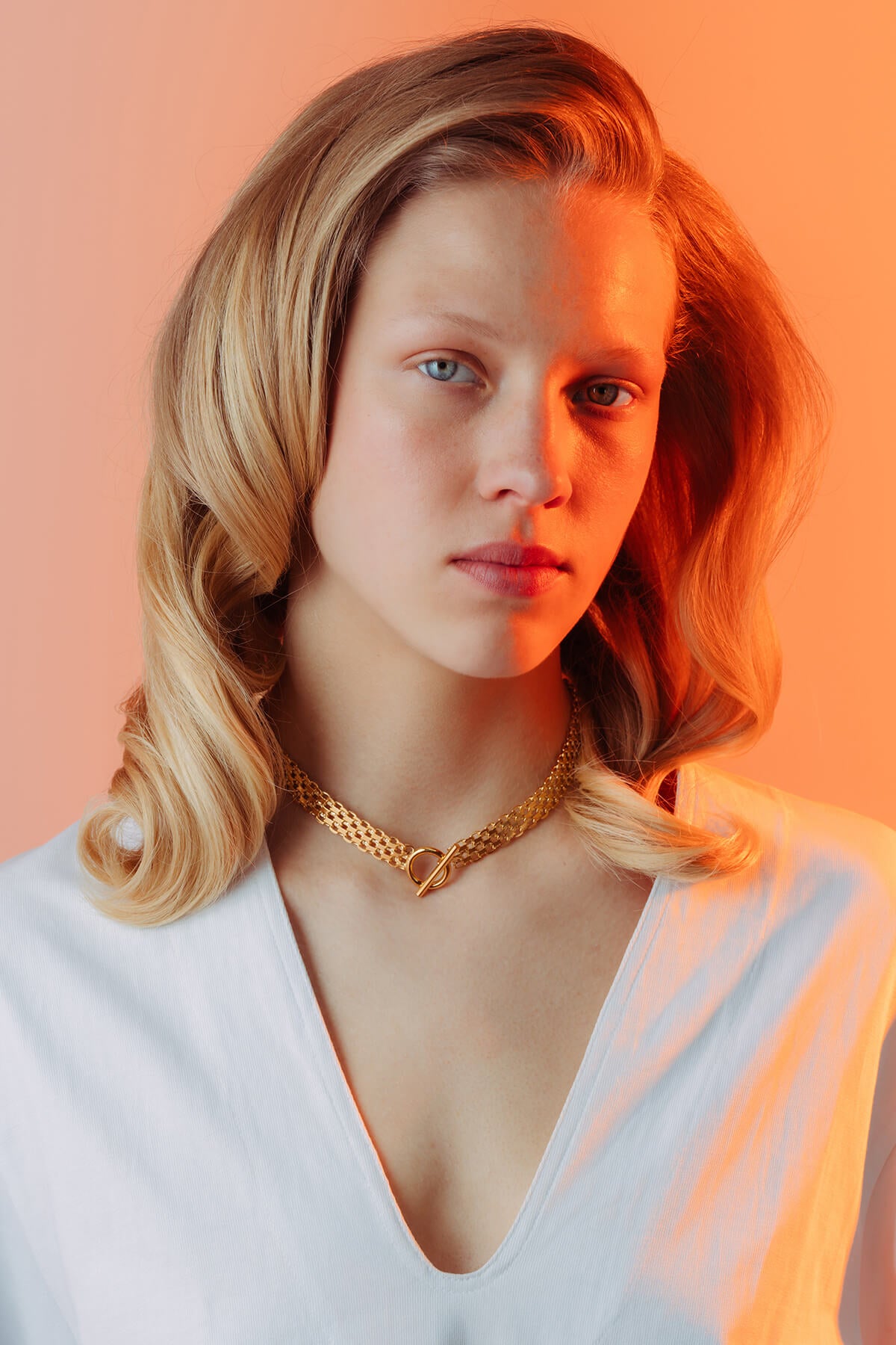 Drip necklace with a gold-tone multi-row chain and front T-bar toggle clasp resting at the neckline.
