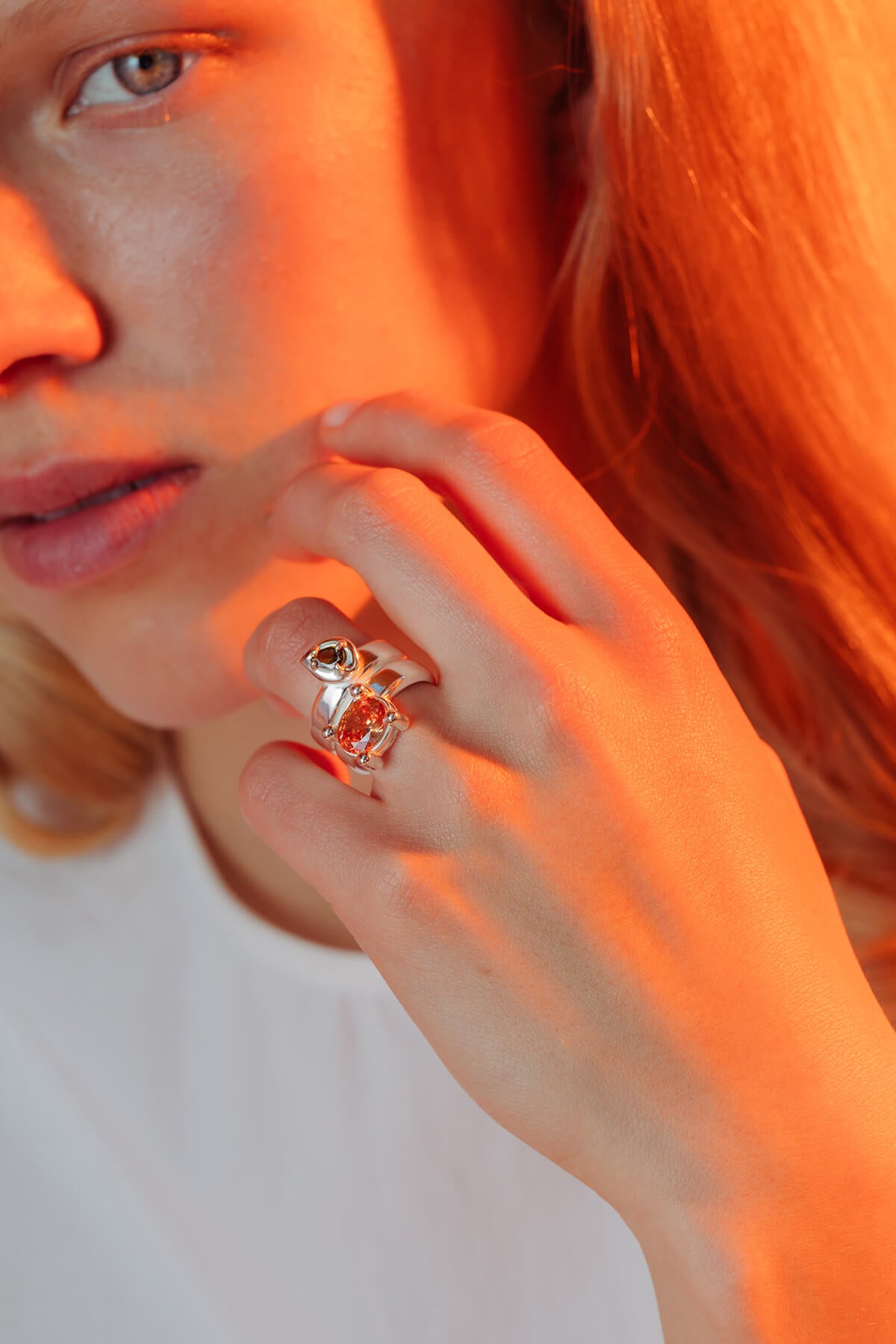 Drip ring with cubic zirconia with oversized settings holding green pear-shaped and orange oval cubic zirconia.