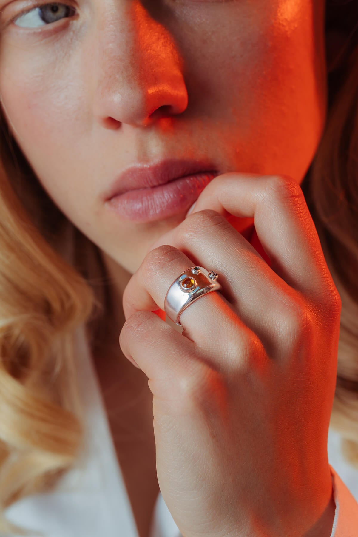 Spill ring with cubic zirconia featuring a wide polished band with blue, green and orange cubic zirconia stones.