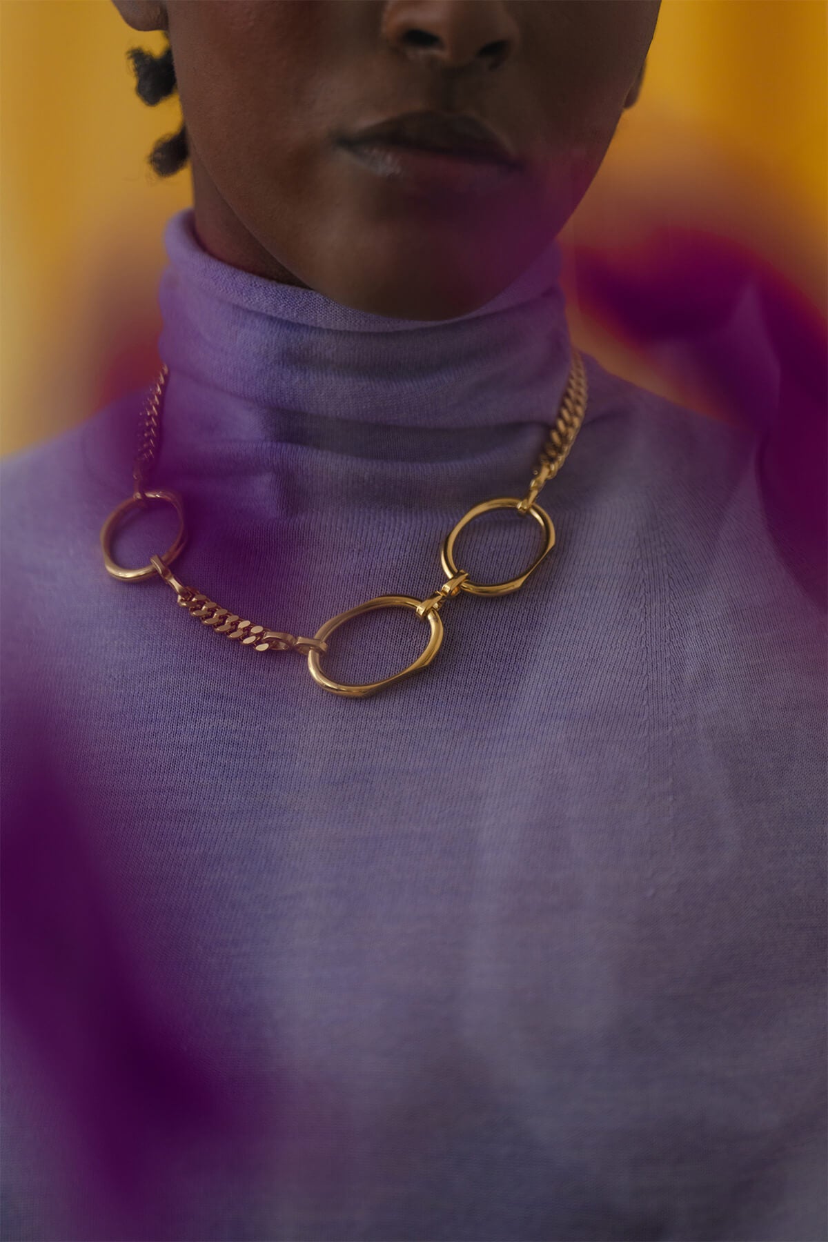 Meseret wearing the bold Facet Necklace - a modern statement necklace with chunky chain and faceted oval forms.