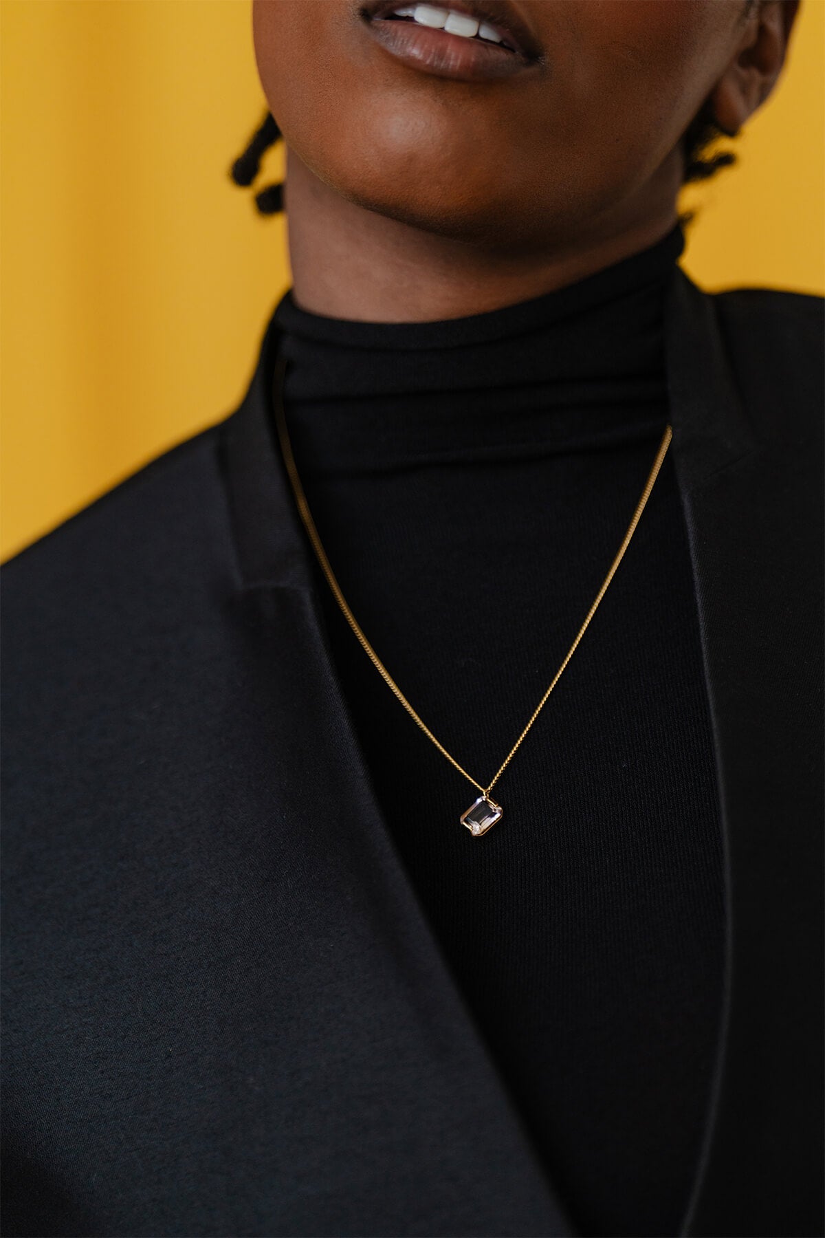 Meseret wearing the Prism Necklace – a refined minimalist design with a diagonally set emerald-cut ametrine and subtle color gradient.