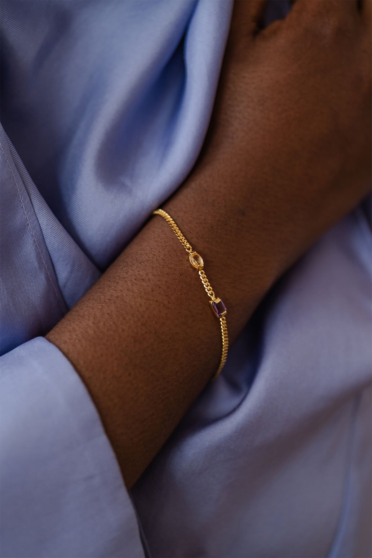 Meseret wearing the Ray Bracelet, a delicate gourmet chain with amethyst, citrine, and a tiny freshwater pearl for everyday.