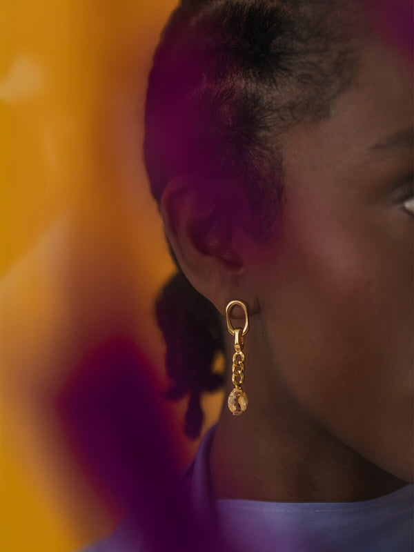 Close-up of the Ray Earrings featuring mismatched lengths, clean-faceted ovals, and a dangling oval-cut citrine.