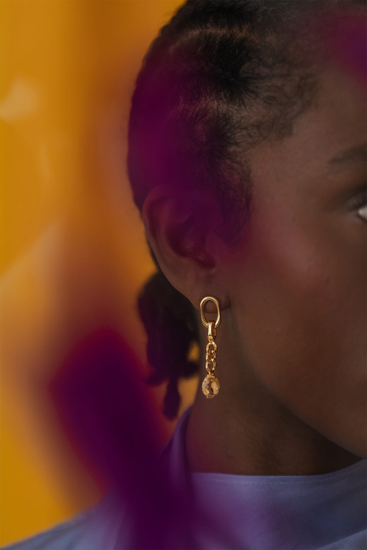Close-up of the Ray Earrings featuring mismatched lengths, clean-faceted ovals, and a dangling oval-cut citrine.