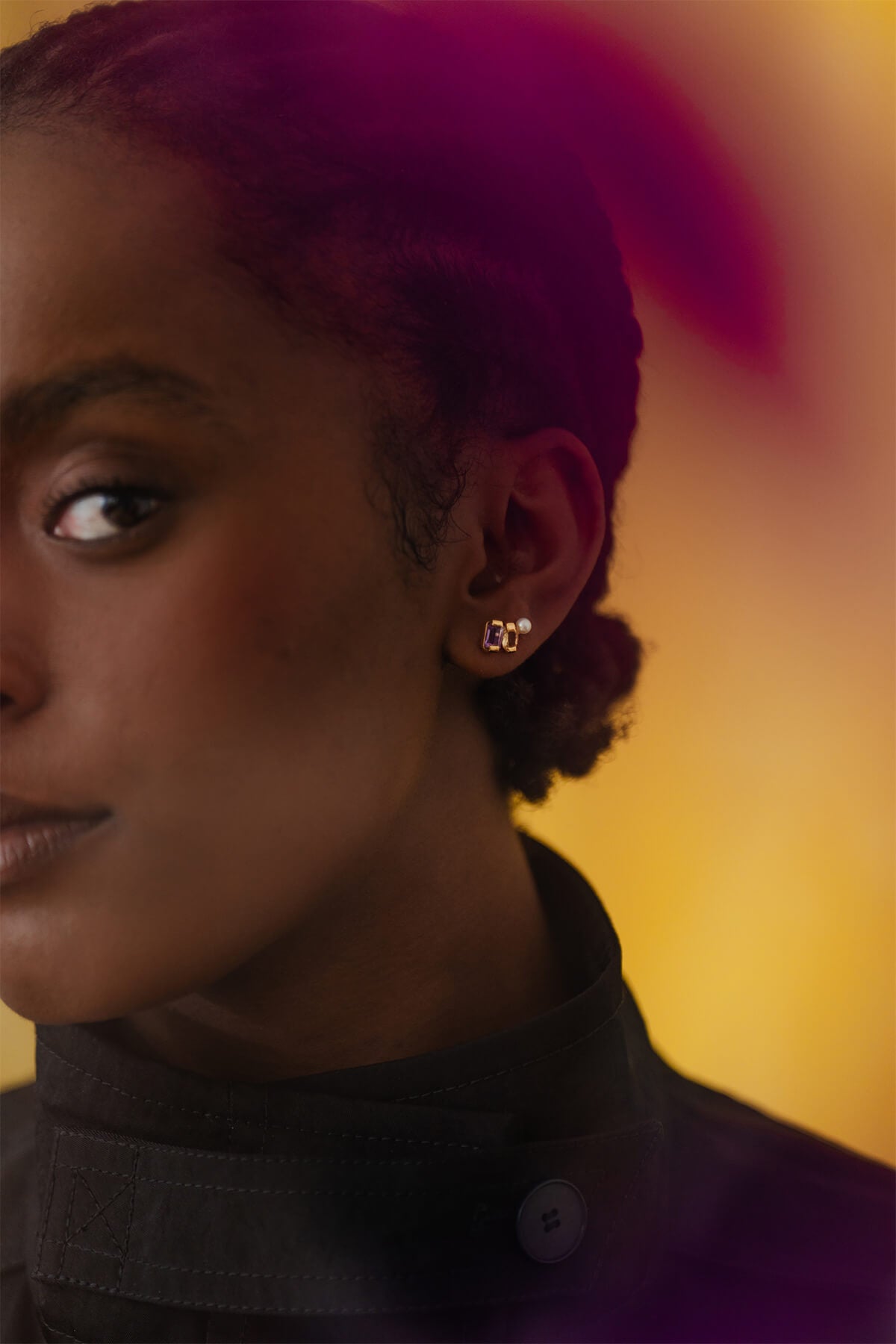 Meseret wearing the Ray Studs – delicate cluster earrings with amethyst, citrine, and a freshwater pearl for subtle color and elegance.