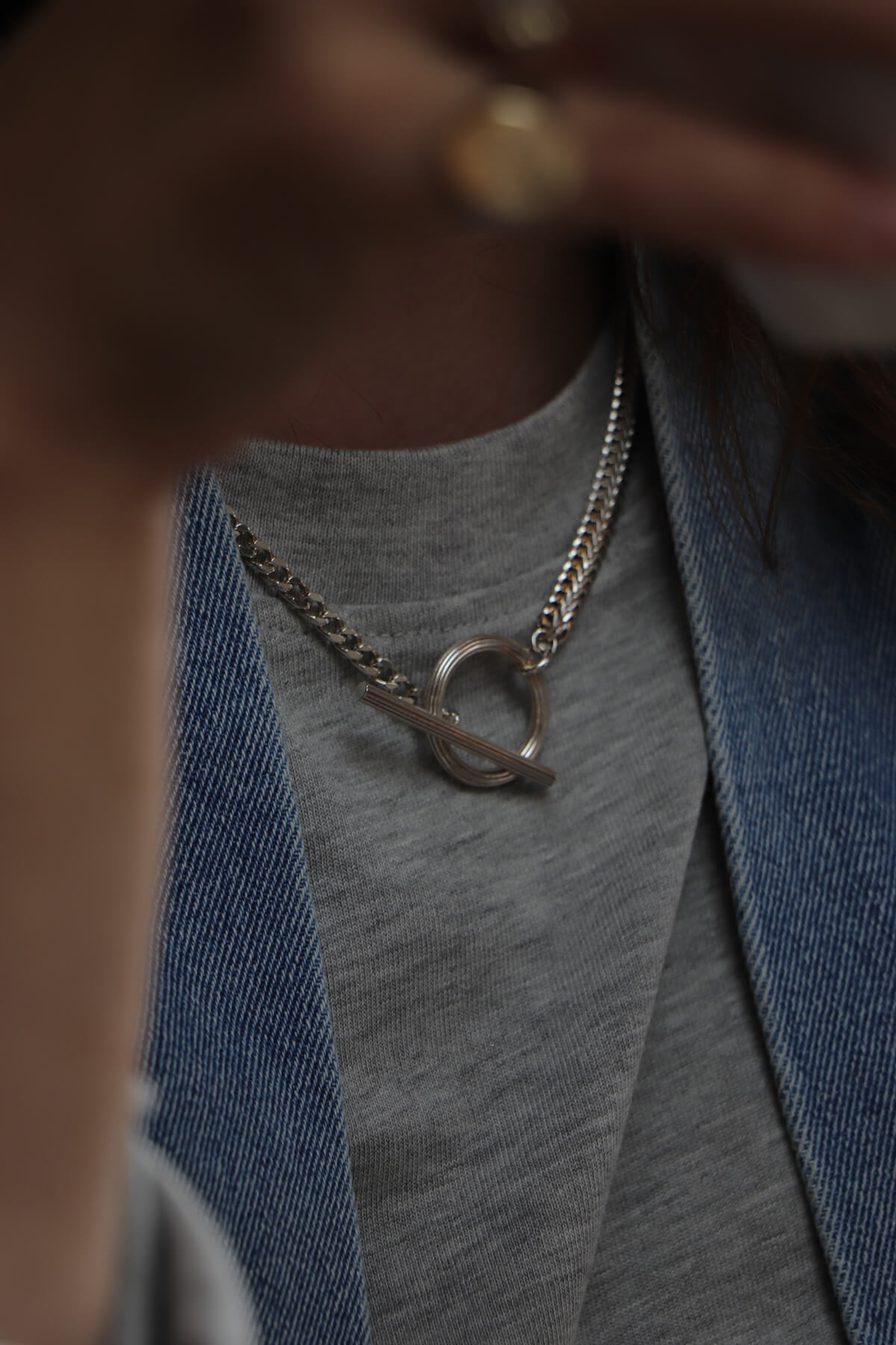 Studio Collect Carve T-necklace, worn with a grey T-shirt and denim jacket.
