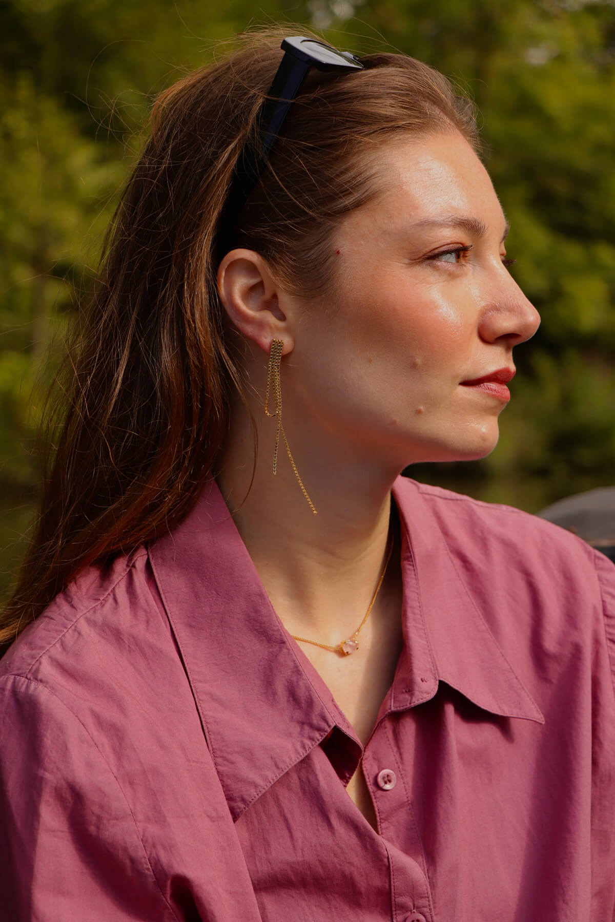 Gold vermeil Studio Collect Strada Draped Earrings worn by Magaly in a outdoor summer setting.