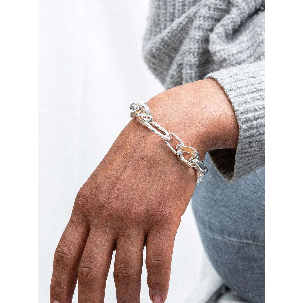Model casually wearing the silver chunky Carve Statement Bracelet on her wrist.